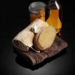 Image: Aromatherapy oils and herbs for pain relief are displayed on a wooden table